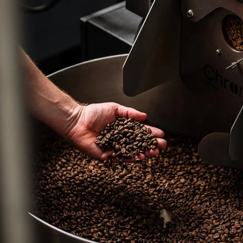 Refroidissement du café apres torréfaction, mains dans le café